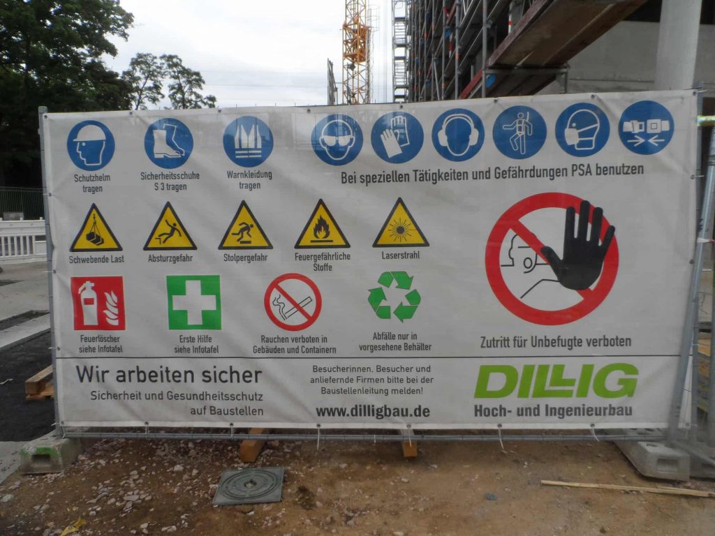 An einer Baustelle angebrachtes Plakat – u. a. auch mit Gebotszeichen für das Tragen von PSA (nach ASR A1.3 „Sicherheits- und Gesundheitsssschutzkennzeichnung“).
